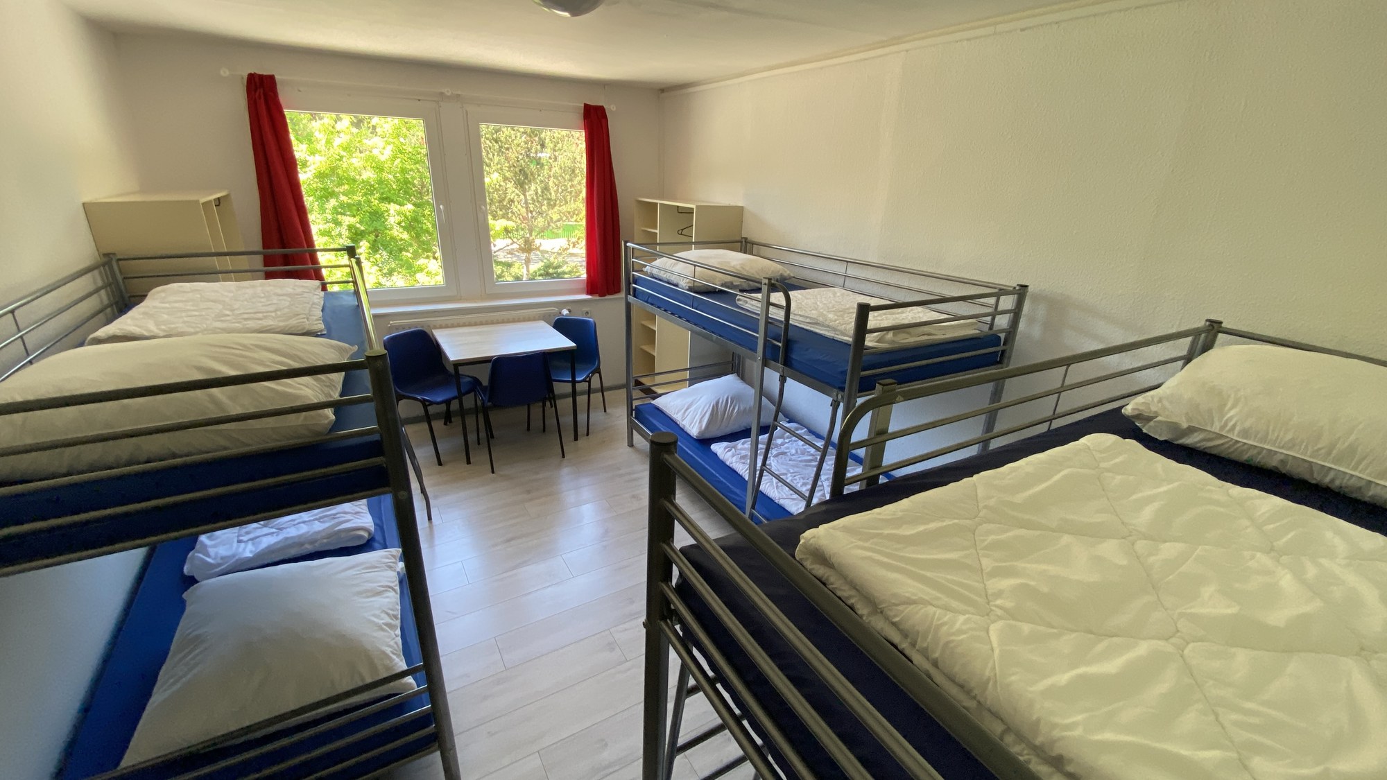 Mehrbettzimmer mit Etagenbetten und Tisch