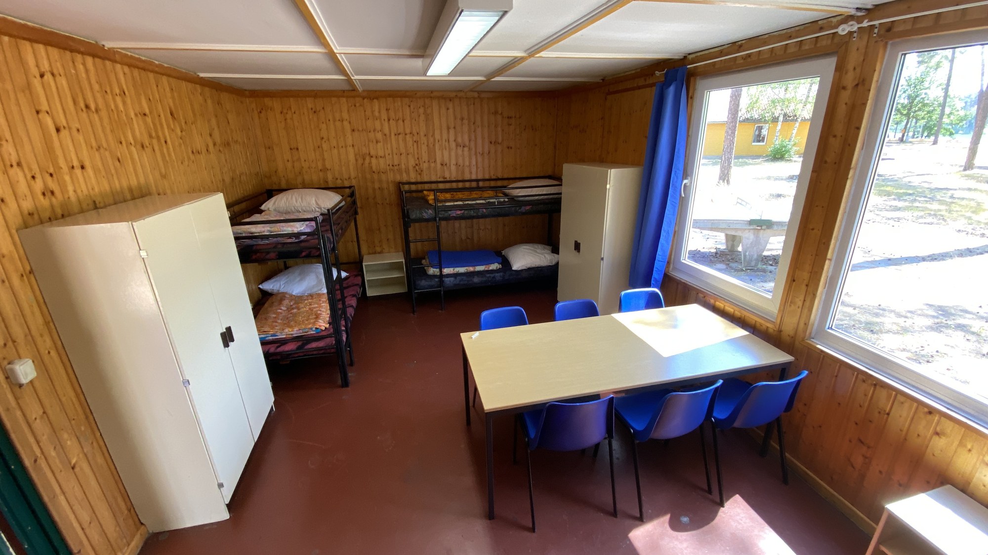 Einfaches Mehrbettzimmer in einem Holzbungalow