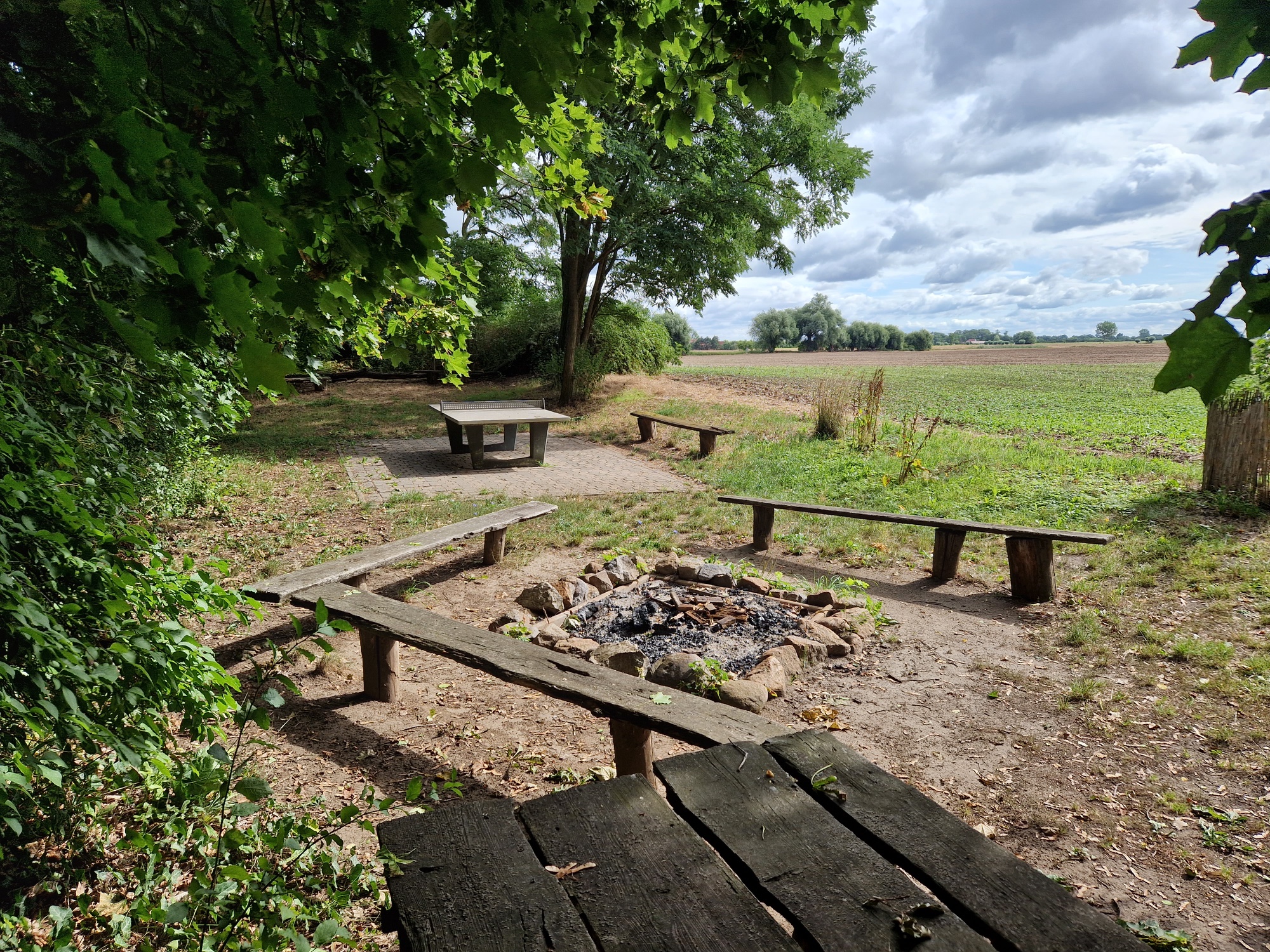 Lagerfeuerstelle, Tischtennisplatte und Blick &uuml;ber die Felder