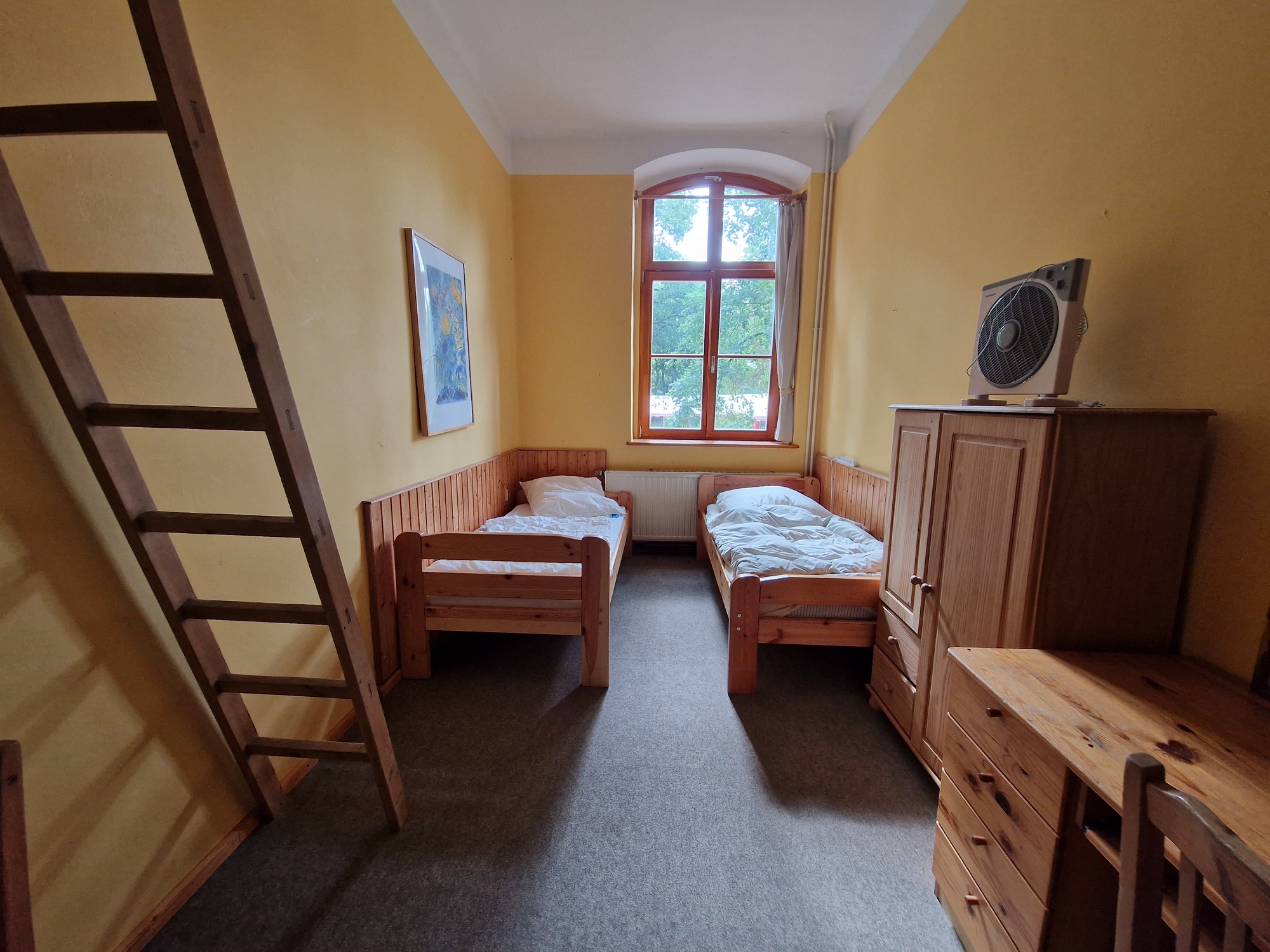 Zweibettzimmer mit Holzbetten und einer Galerie