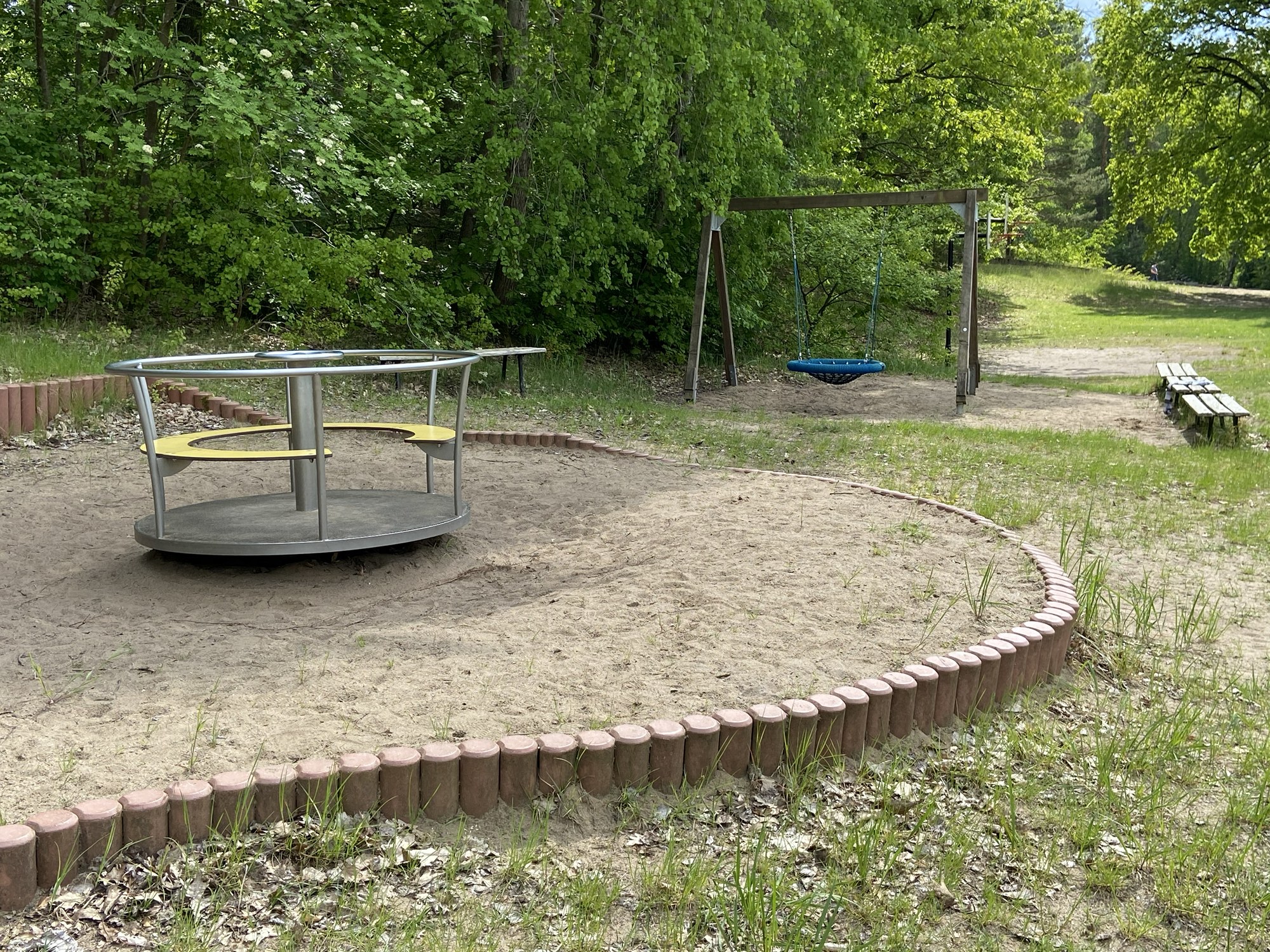 Spielplatz mit Karussell und Schaukel
